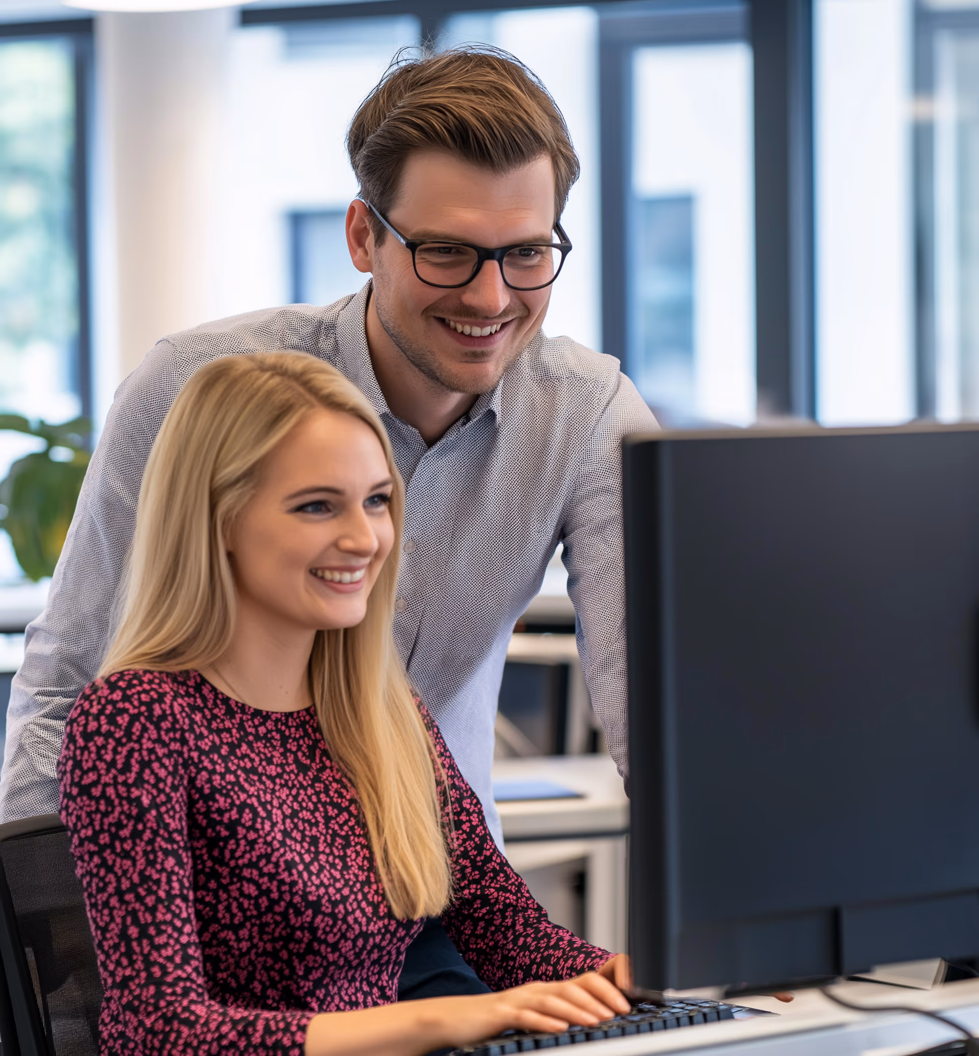 Freundliche IT-Mitarbeiter von Cryon beraten am Schreibtisch
